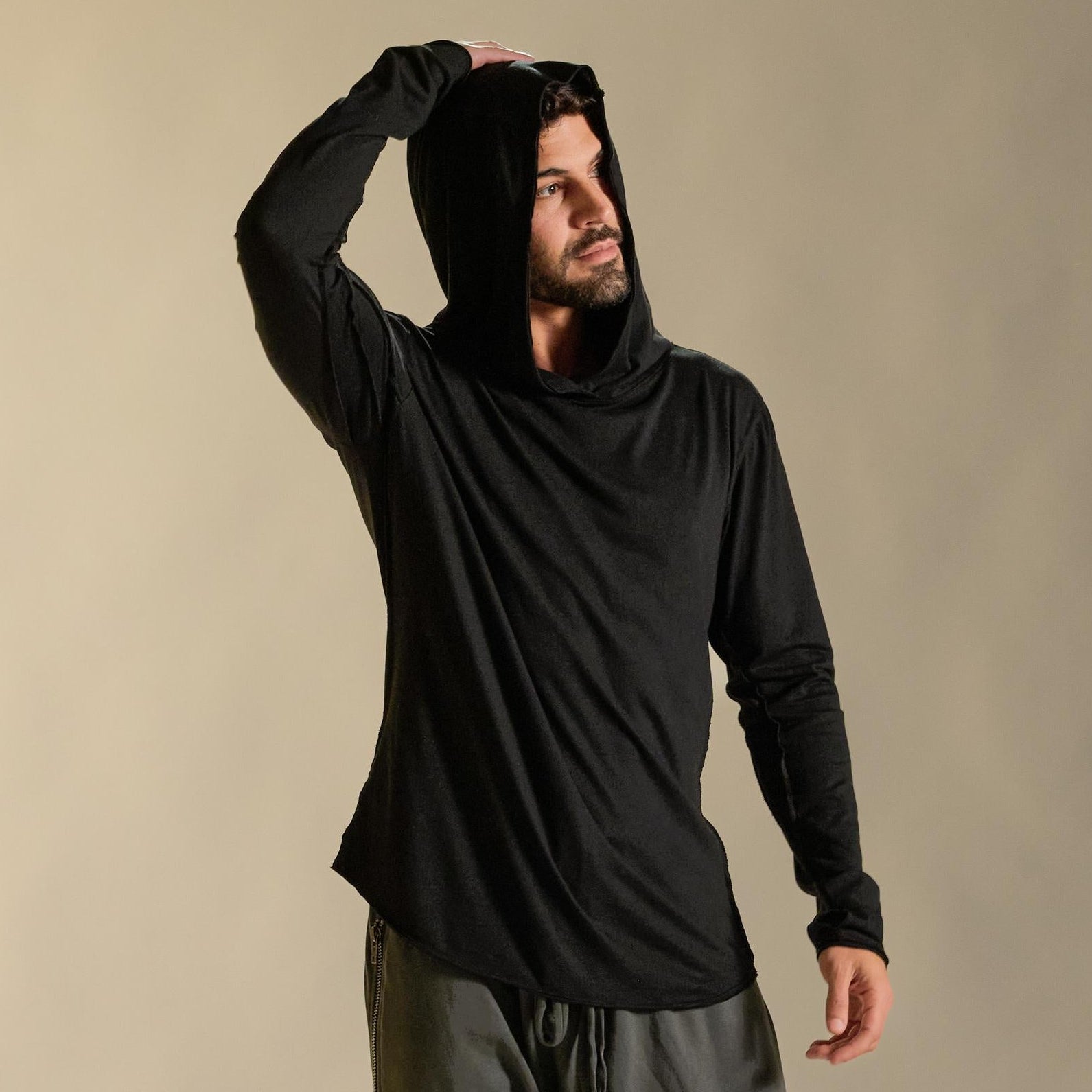 Man modeling black long-sleeve hooded tee