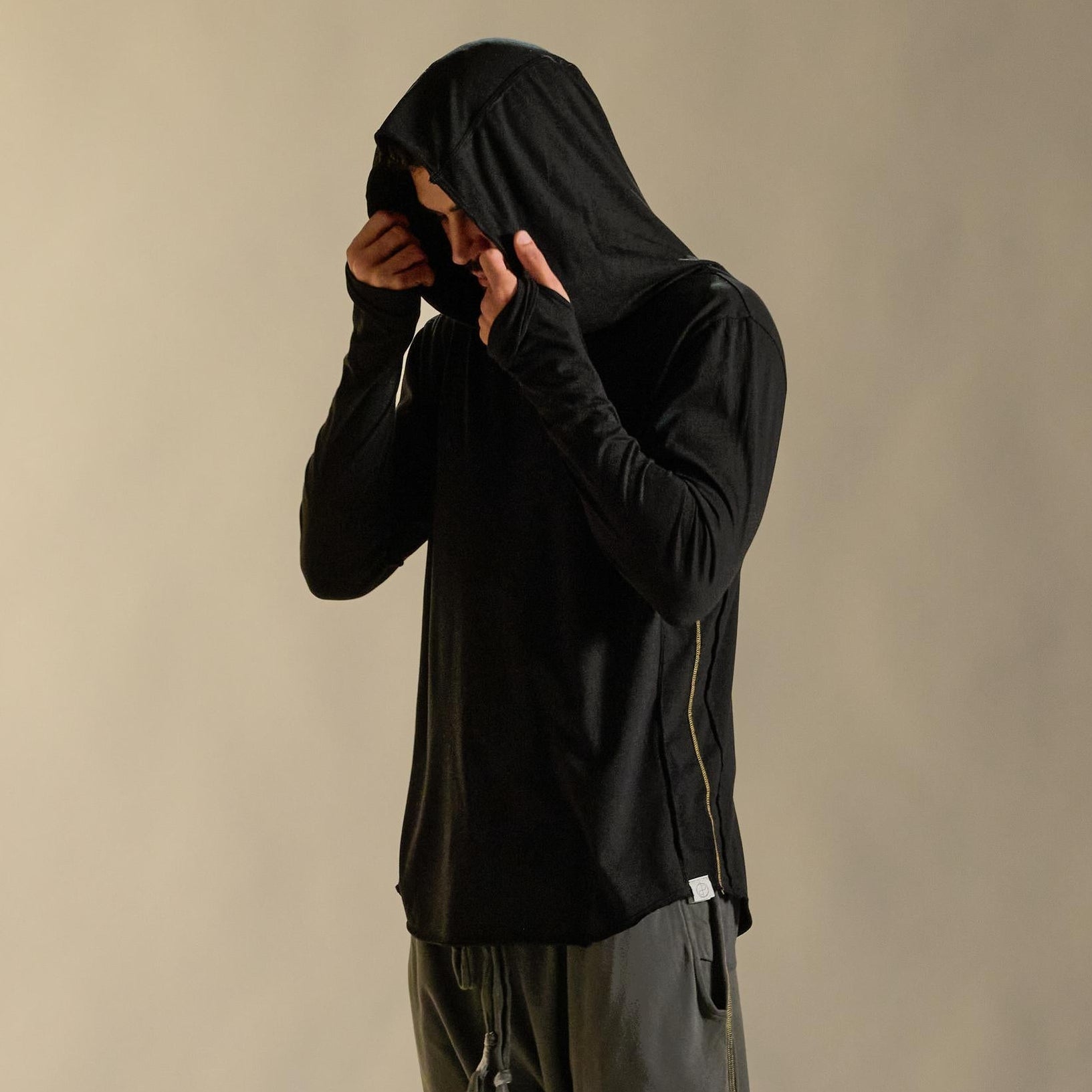 Man modeling black long-sleeve hooded tee