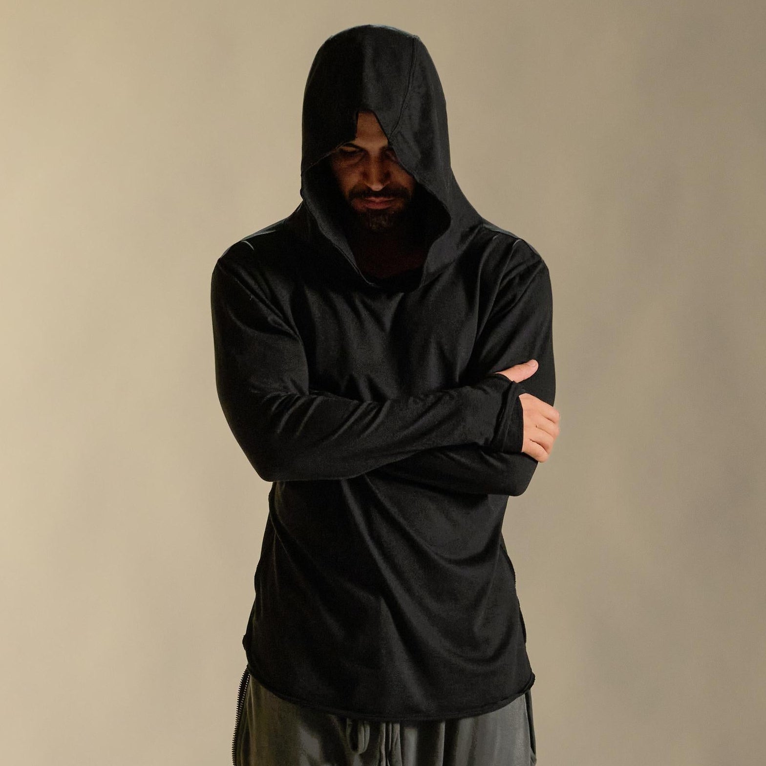 Man modeling black long-sleeve hooded tee