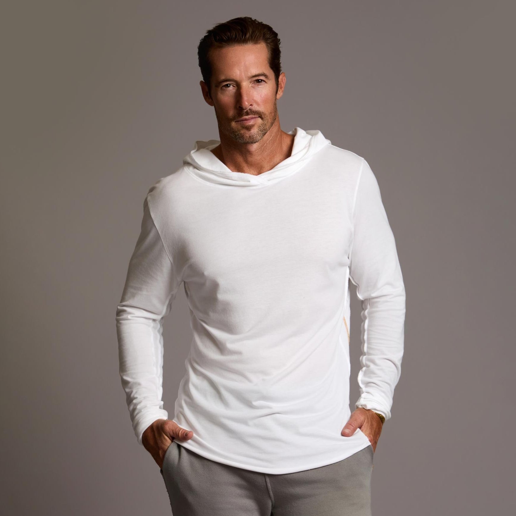 Man modeling white long-sleeve hooded tee